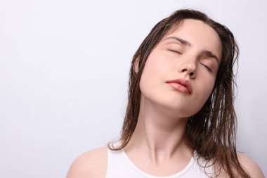 Açık gri arka planda doğal ten rengi olan güzel bir kadın. Yakın plan. Metin için boşluk