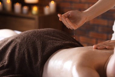 Kaplıcada kadın yağ ile masaj yaptırıyor, yakın plan.