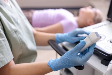 Ultrason makineli sonograf ve klinikteki muayene odasında kız, seçici odaklı.