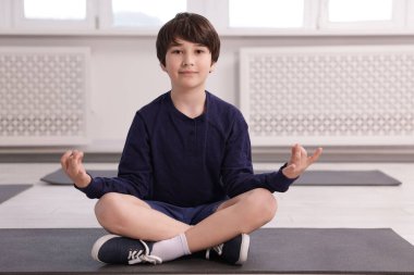 Paspasın üstünde yoga yapan tatlı çocuk.