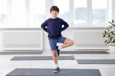 Paspasın üstünde yoga yapan tatlı çocuk.