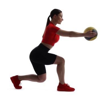 Beyaz arka planda ilaç topuyla egzersiz yapan atletik bir kadın.