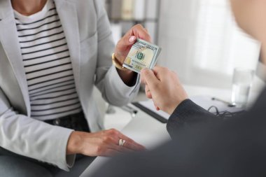 İkramiye. Patron ofisteki çalışana para veriyor, yakın plan.