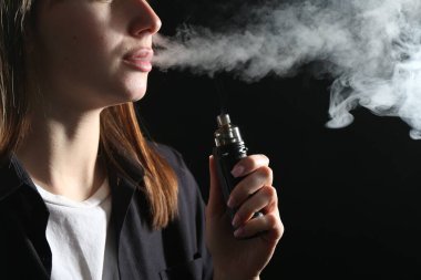 Siyah arkaplanda elektronik sigara içen kadın, yakın plan