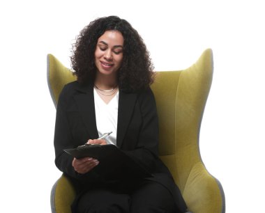 Beyaz arka plandaki koltukta pano ve kalemle profesyonel psikolog.