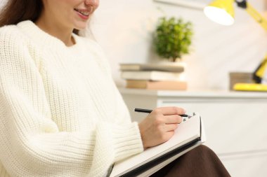 Evdeki ajandada yazan kadın, yakın plan. Metin için boşluk