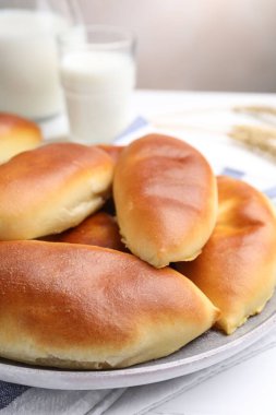 Beyaz ahşap masadaki lezzetli hamur köfteleri ve çiviler gri arka planda, yakın planda.