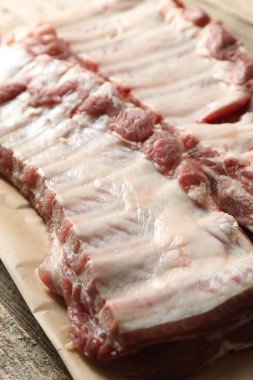 Ahşap masada çiğ domuz pirzolası, yakın plan.