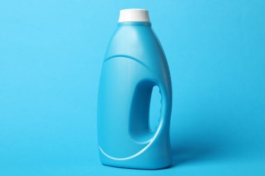 Açık mavi arkaplanda bir şişe yumuşatıcı