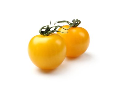 Olgun sarı kiraz domatesleri beyazlar üzerinde izole.