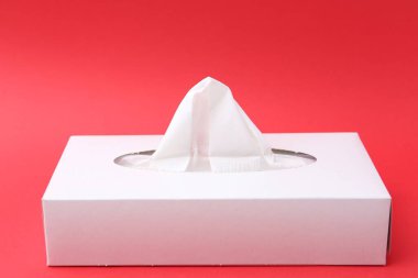 Kırmızı arkaplanda kağıt mendilli kutu, yakın plan