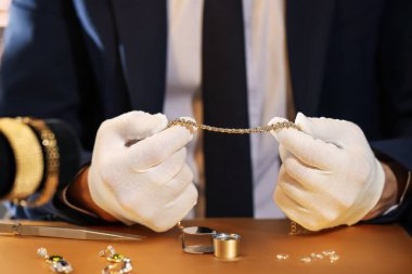 Masada lüks takılarla çalışan eksper, yakın plan.