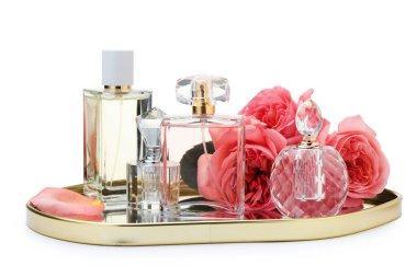 Birçok farklı parfüm şişeleri ve güller beyaz üzerine izole edilmiş.