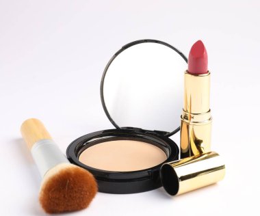 Beyaz arkaplanda ayna, fırça ve ruj ile yüz pudrasını aç