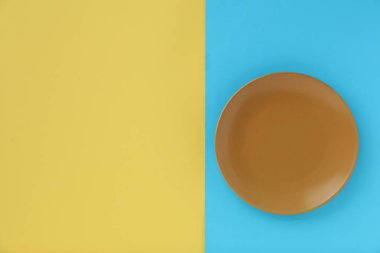 Renkli arka planda boş tabak, üst görünüm. Metin için boşluk