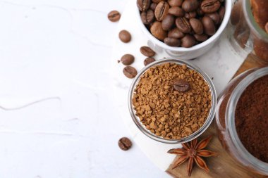 Farklı türde hazır kahve, fasulye ve baharatlar açık dokulu masa, üst görünüm. Metin için boşluk