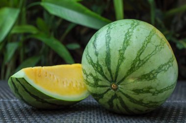 Açık havada hasır masada sarı karpuzlar var, yakın plan.