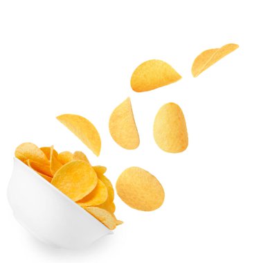 Lezzetli patates cipsleri beyaz arka planda kaseye düşüyor.