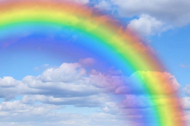 Mavi gökyüzünde parlak gökkuşağı güneşli bir günde bulutlarla