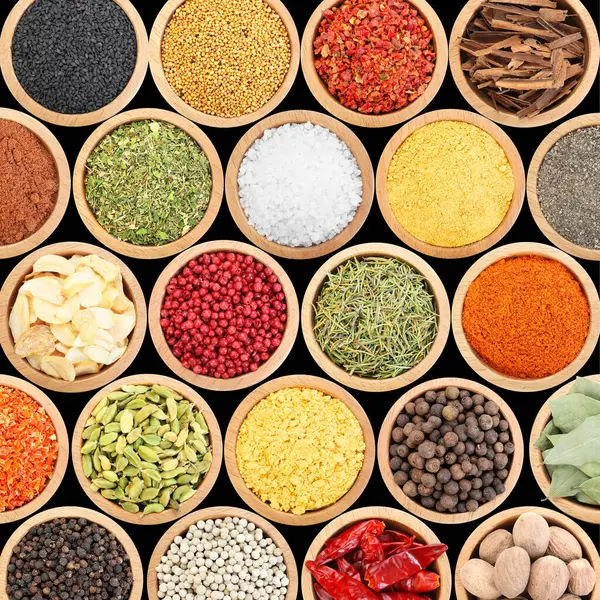 Siyah arka plandaki kaselerde farklı aromatik baharatlar dizisi.