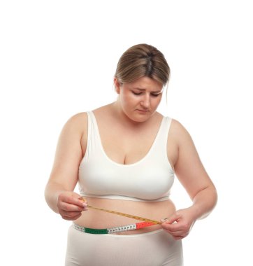 Kilo kaybı. Artı, beyaz arka planda bantla bel ölçüsü ölçen bir kadın.