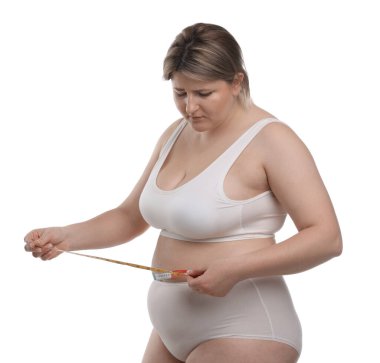 Kilo kaybı. Artı, beyaz arka planda bantla bel ölçüsü ölçen bir kadın.