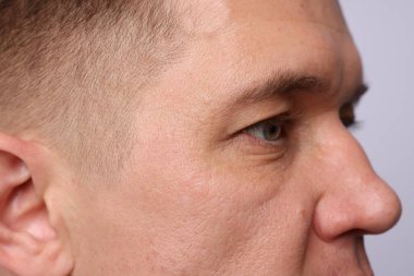 Aydınlık arkaplanda yakışıklı bir adam, yakın plan görüntüsü