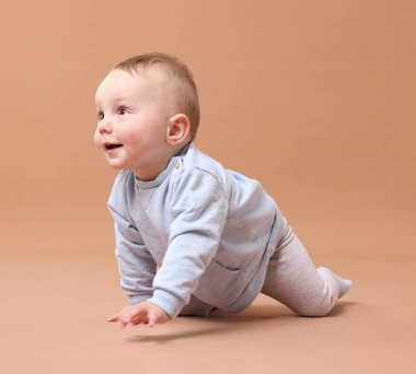 Bej arka planda emekleyen şirin bir bebek.