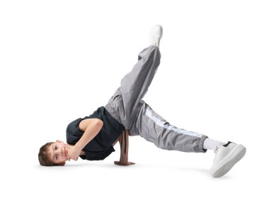 Beyaz arka planda dans eden şık elbiseli bir çocuk.