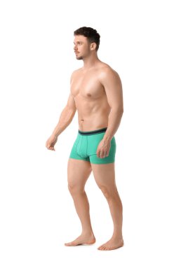 Beyaz arka planda şık turkuaz iç çamaşırlı genç adam.