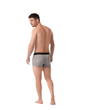 Beyaz arka planda açık gri iç çamaşırlı genç adam.