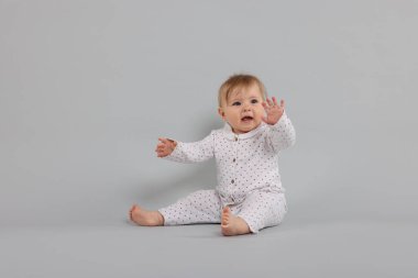 Açık gri arka planda şirin bir bebek.