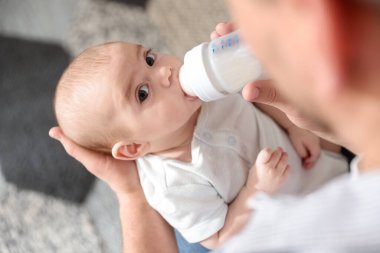 Babası bebeğini biberonla besliyor.