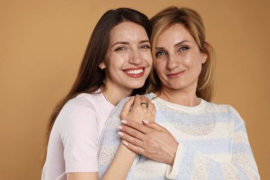 Bej arka planda anne ve kızının portresi