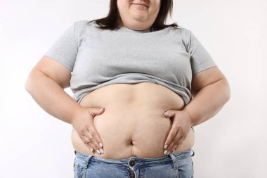 Beyaz arka planda aşırı göbek yağı olan kadın, yakın plan.
