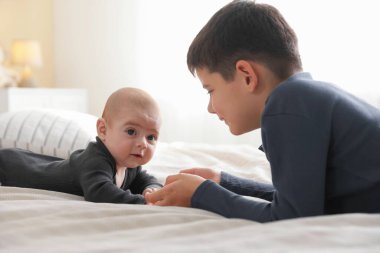 Evde el ele tutuşan sevimli küçük kardeşler.