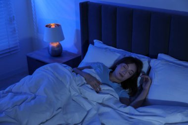 Güzel bir kadın yatağında uyuyor, manzaranın üstünde.