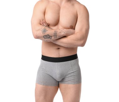 Beyaz arka planda açık gri iç çamaşırlı genç adam, yakın plan.