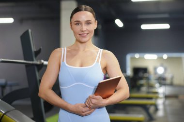 Spor salonunda tableti olan profesyonel kişisel antrenör.