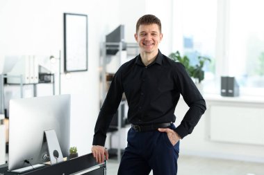 Ofisteki masanın yanındaki yakışıklı adamın portresi.