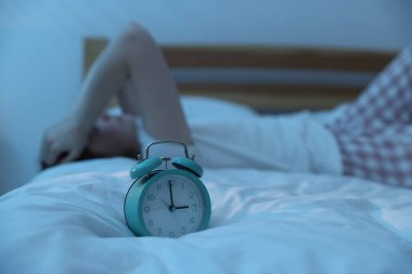 Evde yatakta uykusuzluk çeken sinirli genç kadın, alarma odaklan.