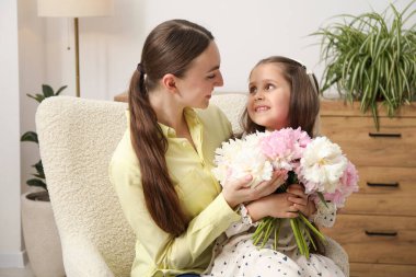 Sevimli küçük kız, annesine bir buket güzel şakayık veriyor.
