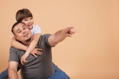 Babası ve oğlu bej arka planda, mesaj için yer var.
