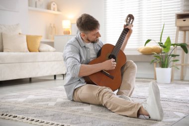 Evde gitar çalan adam.