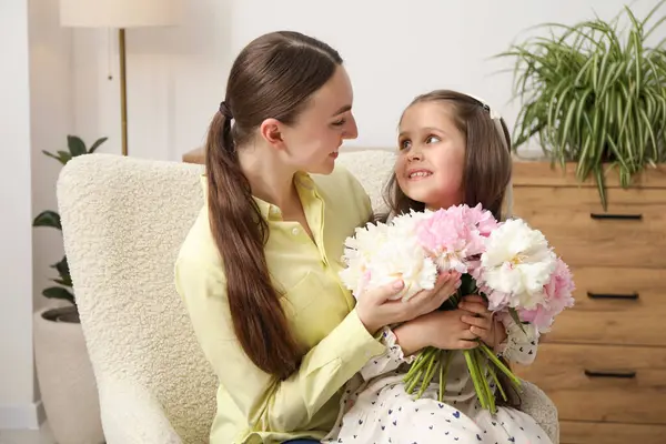 Sevimli küçük kız, annesine bir buket güzel şakayık veriyor.