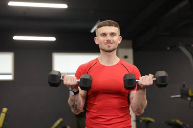 Spor salonunda dambılı olan profesyonel kişisel antrenör.