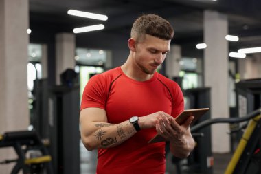 Spor merkezinde tableti olan kişisel antrenör.