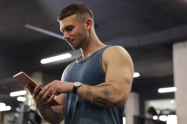 Spor merkezinde tableti olan kişisel antrenör.