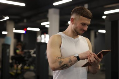 Spor merkezinde tableti olan kişisel antrenör. Metin için boşluk