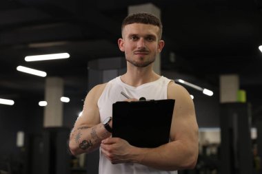 Spor merkezinde panosu olan kişisel antrenör.